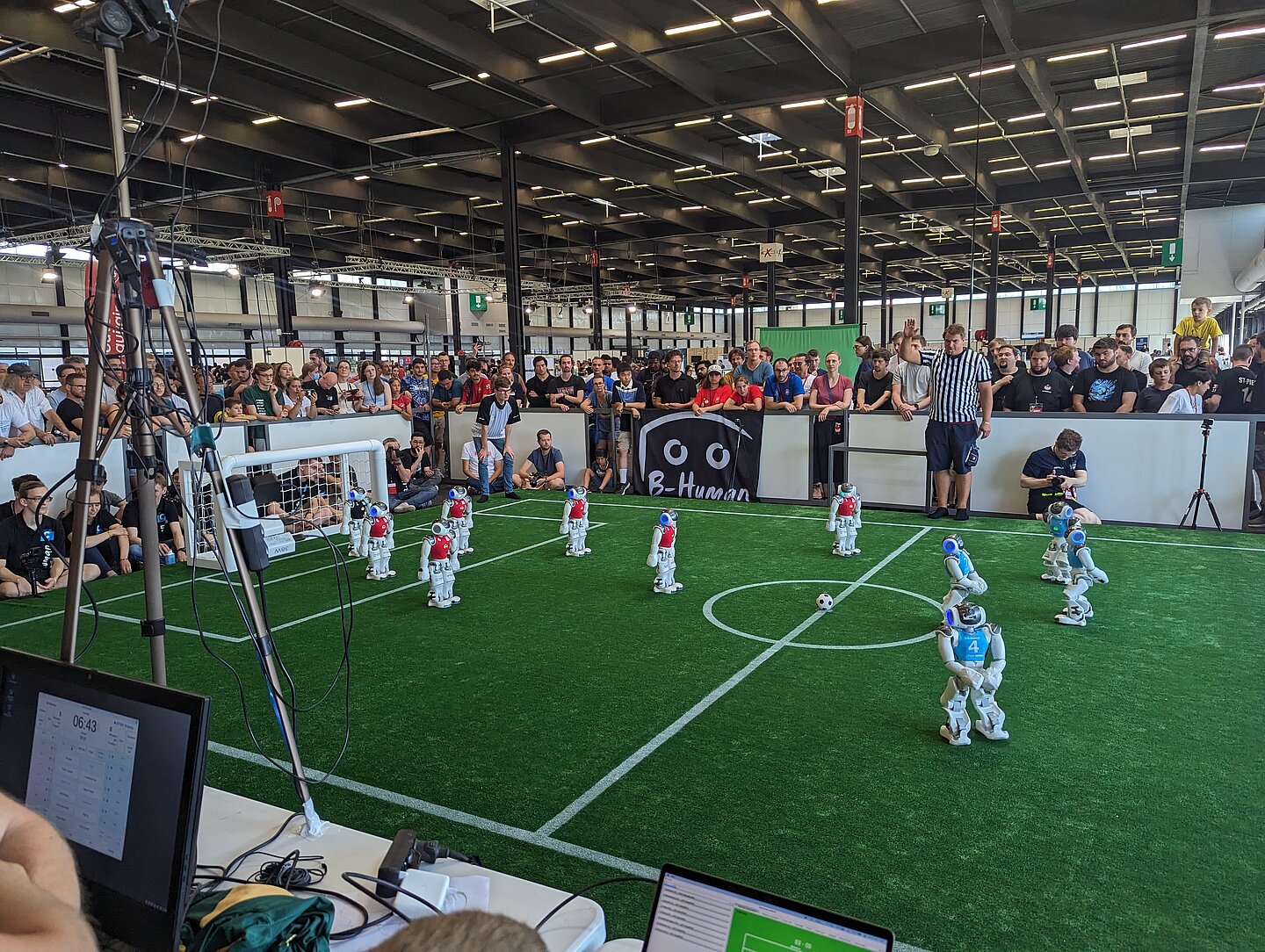 Das Finalspiel in Bordeaux. (Foto: HTWK Robots) kleine Fußbrallroboter auf grünem Kunstrasen