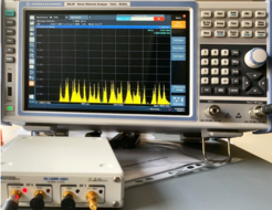 spectrum analyzer showing a spectrum generated by a software defined radio in front of it