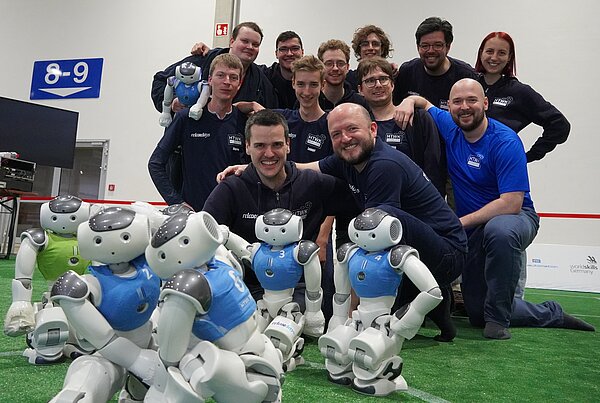 Das Team der HTWK Robots. (Foto: HTWK Robots) Gruppe von Menschen mit humanoiden Robotern