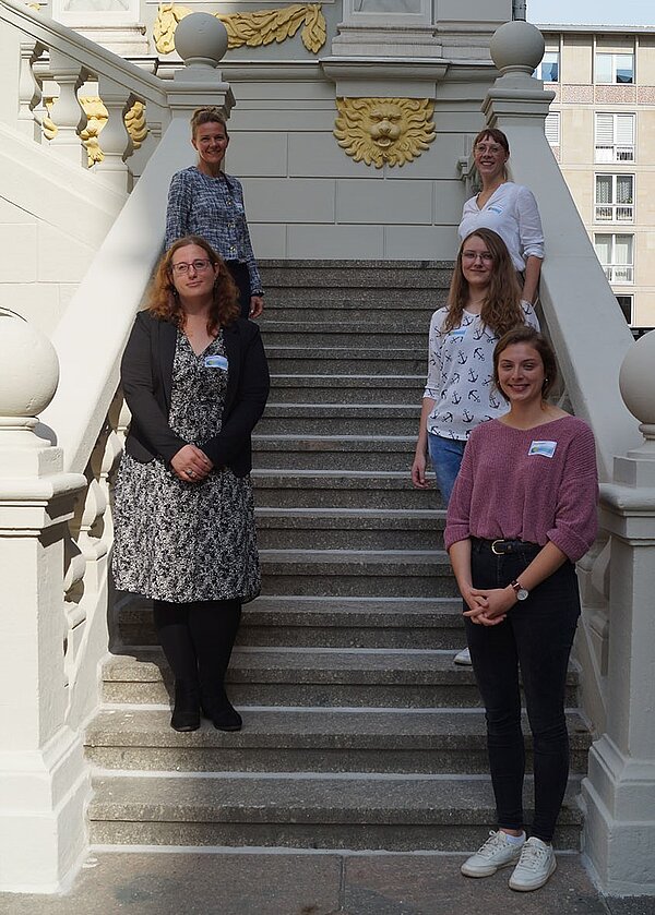 Vier Studentinnen mit zentraler HTWK-Gleichstellungsbeauftragter auf der Treppe der Alten Handelsbörse in Leipzig.