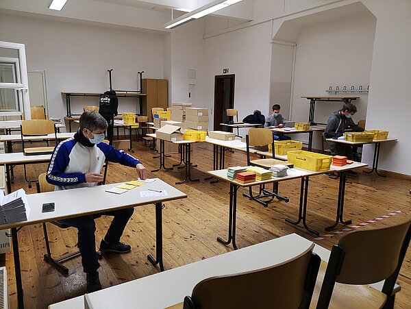 Die fleißigen Helfer*innen Studierende am Verpacken der Stimmzettel