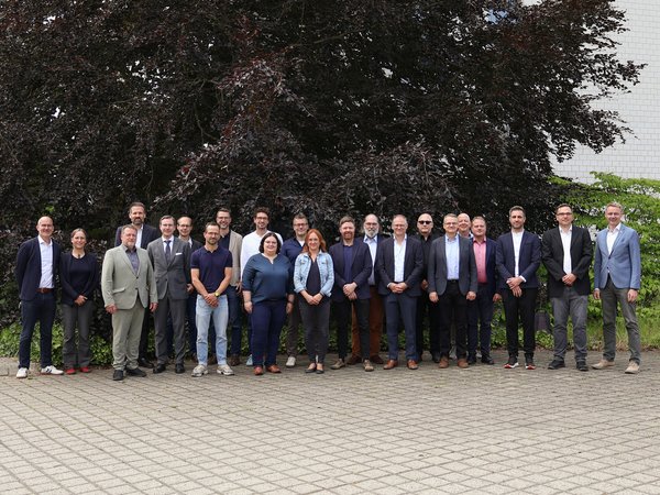 Gruppenbild 30 Personen stehen im Freien für ein Gruppenbild nebeneinander