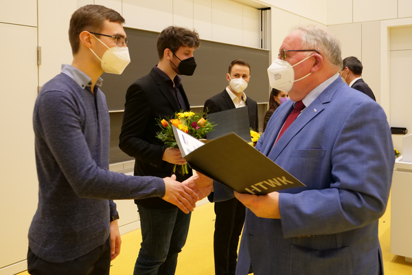 Preisträger mit Masken erhalten Urkunden überreicht