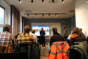 DemoDay Drucksondierung Mann steht vor sitzendem Publikum und hält Vortrag