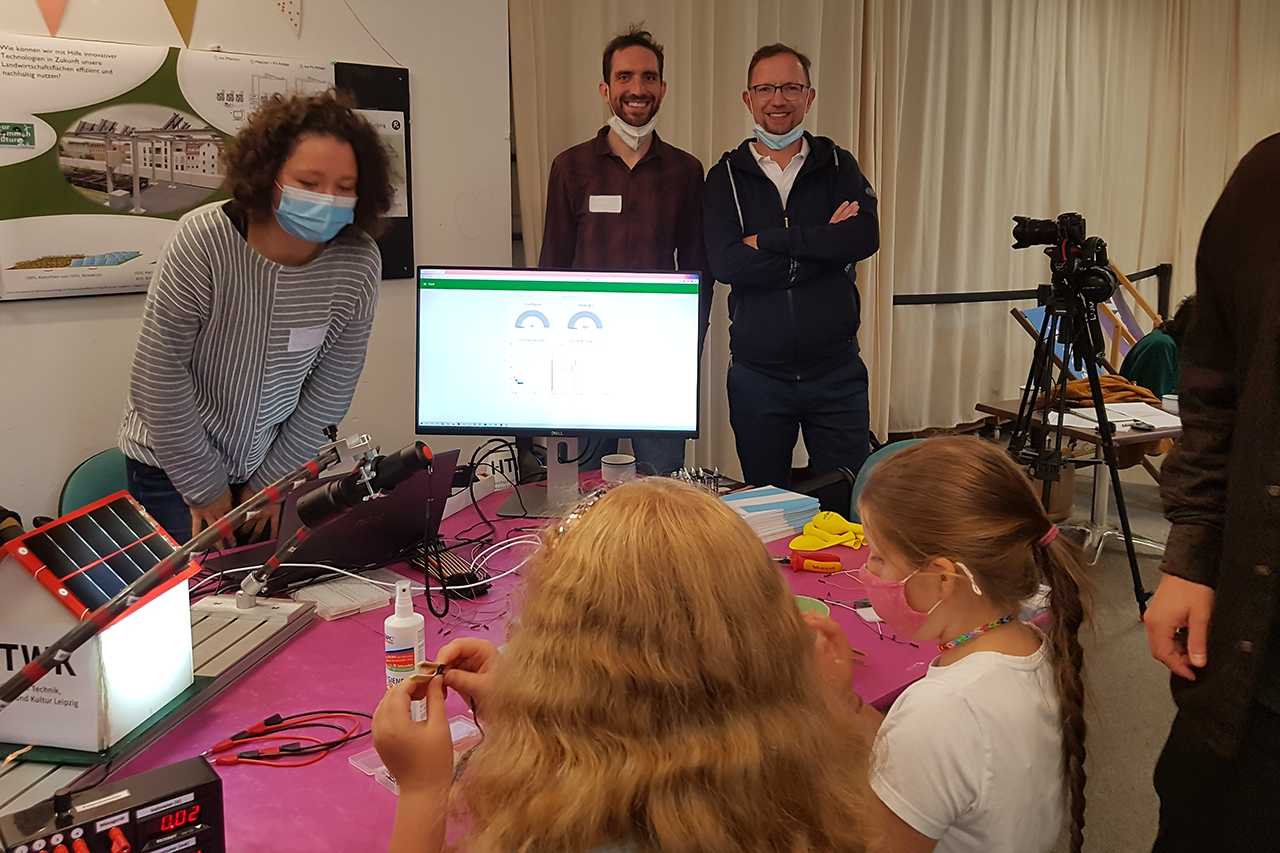 Foto von Workshop mit Schülerinnen, alle tragen Maske und sitzen an Tisch und arbeiten